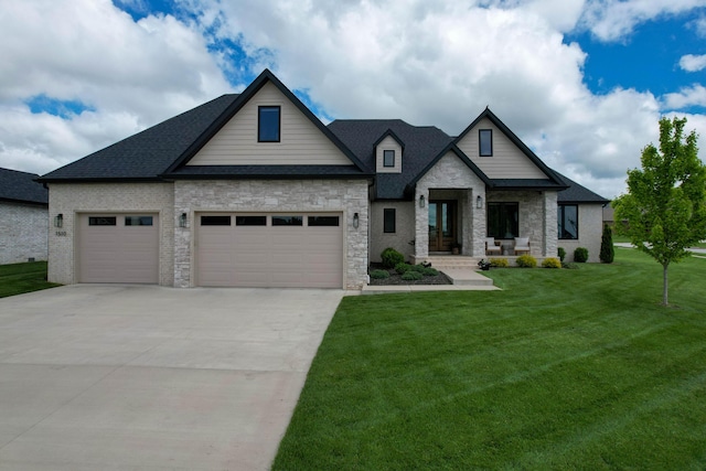 view of front of home featuring stone siding, an attached garage, a front yard, driveway, and roof with shingles