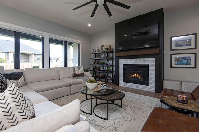 living room with ceiling fan, wood finished floors, a tile fireplace, and recessed lighting