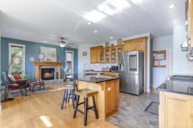5998 S Parkhaven Ln, Springfield, MO 65810 - kitchen with appliances with stainless steel finishes, a sink, ceiling fan, glass insert cabinets, and a fireplace