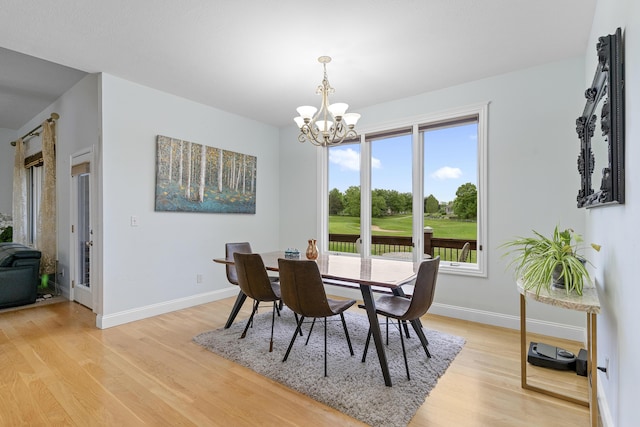 5998 S Parkhaven Ln, Springfield, MO 65810 - dining room with a chandelier, golf course view, light wood finished floors, and baseboards
