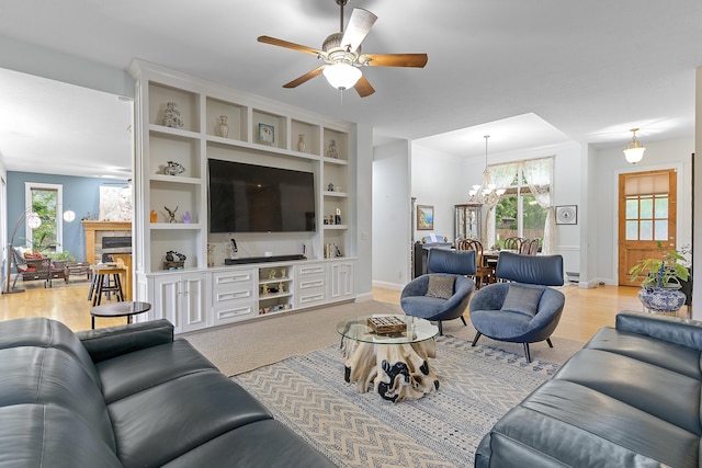 5998 S Parkhaven Ln, Springfield, MO 65810 - living area with a stone fireplace, healthy amount of natural light, a ceiling fan, and a chandelier