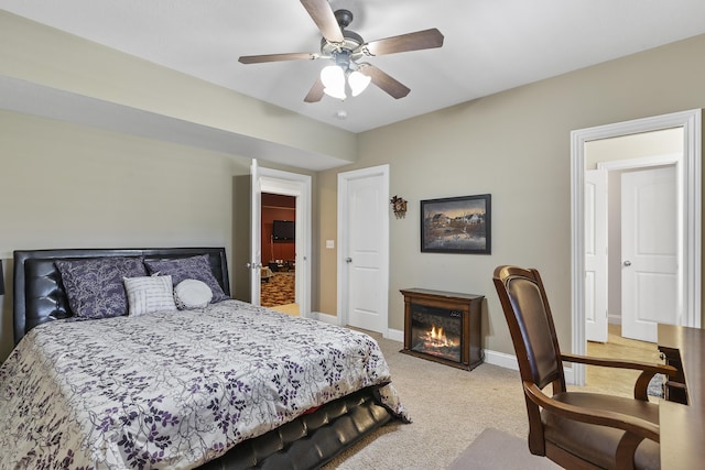 5998 S Parkhaven Ln, Springfield, MO 65810 - bedroom with light colored carpet, a lit fireplace, baseboards, and ceiling fan