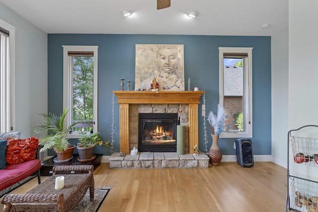5998 S Parkhaven Ln, Springfield, MO 65810 - living room with a stone fireplace, wood finished floors, and baseboards