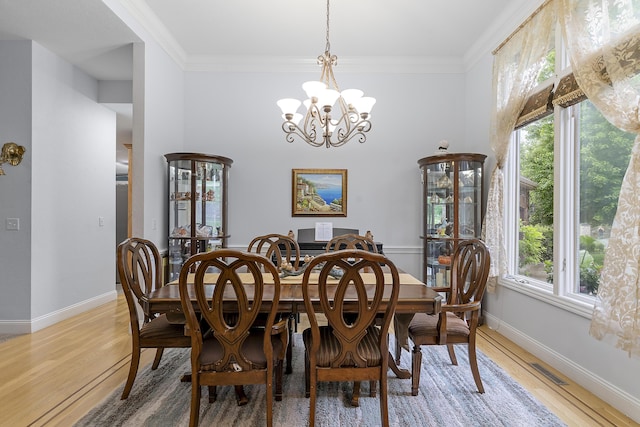 5998 S Parkhaven Ln, Springfield, MO 65810 - dining area featuring a chandelier, light wood-style flooring, crown molding, and baseboards
