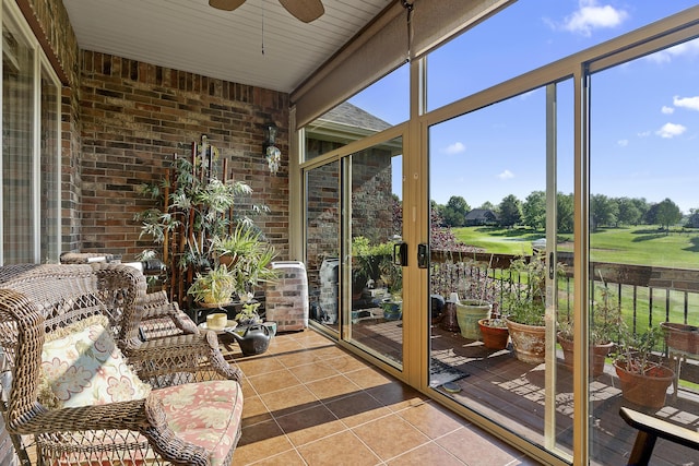 5998 S Parkhaven Ln, Springfield, MO 65810 - sunroom with golf course view, ceiling fan, tile patterned flooring, plenty of natural light, and brick wall