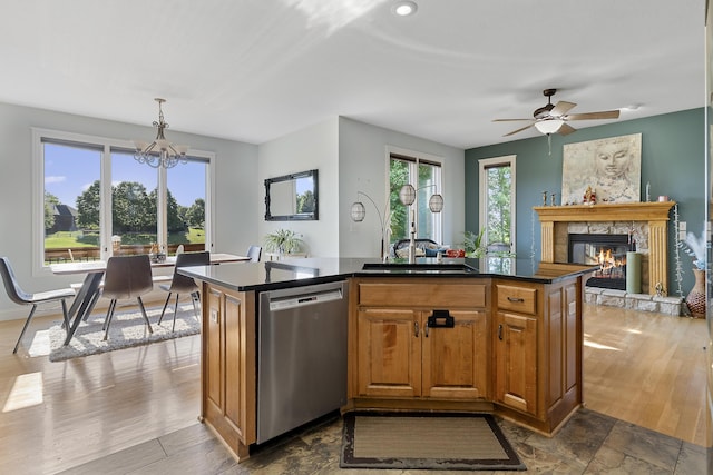 5998 S Parkhaven Ln, Springfield, MO 65810 - kitchen featuring stainless steel dishwasher, a fireplace, dark countertops, a chandelier, and brown cabinetry