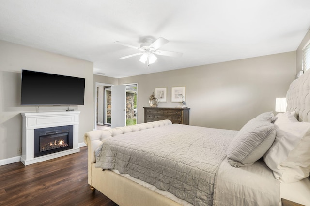 1294 Acacia Club Rd, Hollister, MO 65672 - bedroom with wood finished floors, a glass covered fireplace, baseboards, and a ceiling fan