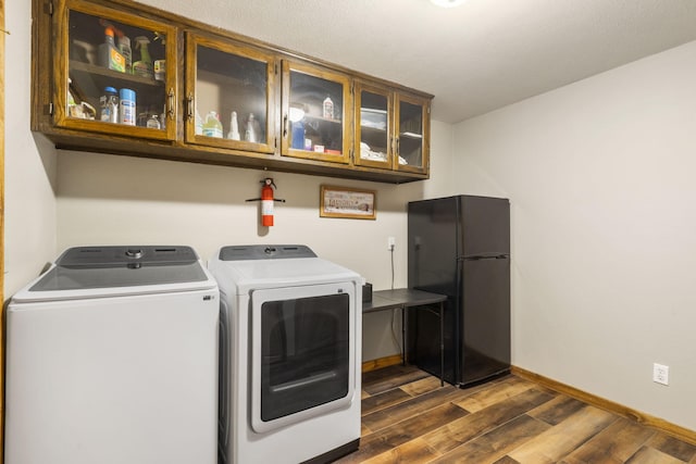 1294 Acacia Club Rd, Hollister, MO 65672 - washroom featuring cabinet space, separate washer and dryer, dark wood-type flooring, and baseboards