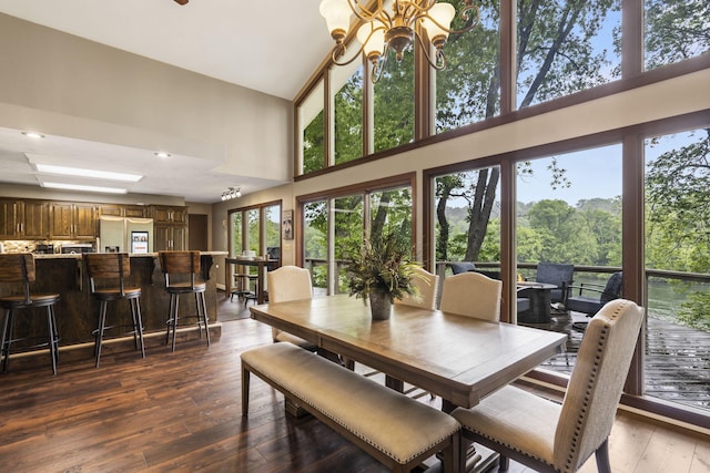 1294 Acacia Club Rd, Hollister, MO 65672 - dining area with a towering ceiling, a chandelier, and dark wood-type flooring