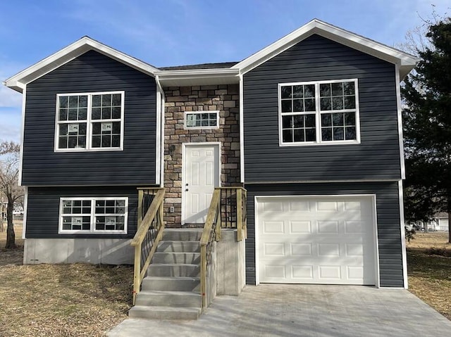 1712 S Jackson St, El Dorado Springs, MO 64744 - raised ranch featuring stone siding, a garage, and concrete driveway