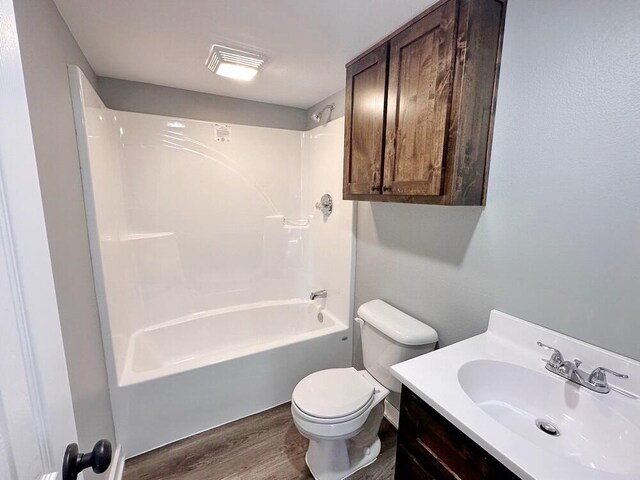1712 S Jackson St, El Dorado Springs, MO 64744 - full bath with wood finished floors, toilet, washtub / shower combination, and vanity