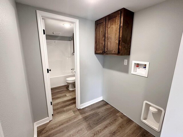 1712 S Jackson St, El Dorado Springs, MO 64744 - clothes washing area featuring cabinet space, hookup for a washing machine, dark wood-type flooring, and baseboards