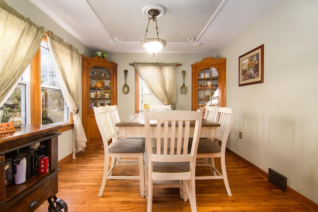 dining area with light wood-style floors and baseboards