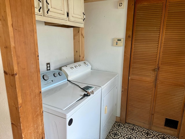 clothes washing area featuring washer and dryer and cabinet space