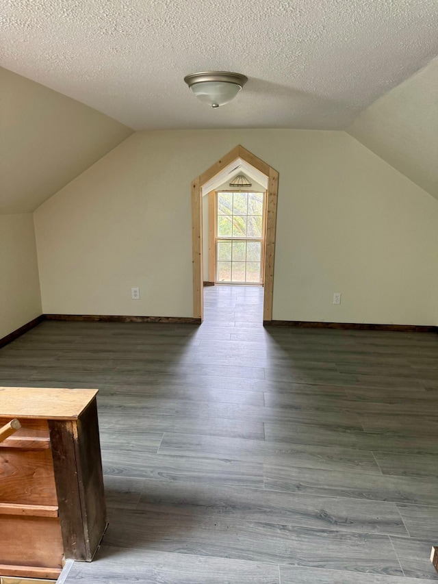 bonus room featuring lofted ceiling, wood finished floors, and baseboards