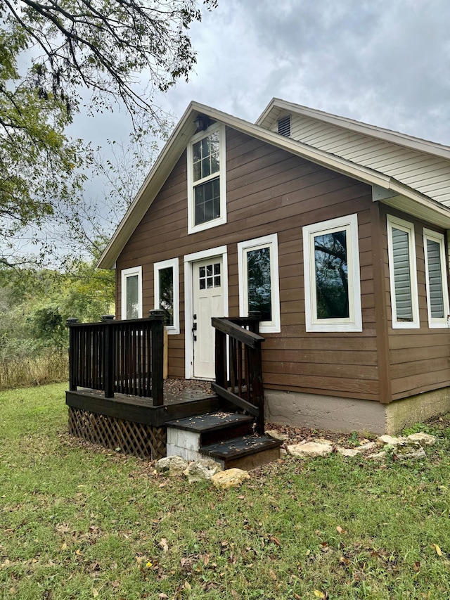 rear view of property featuring a yard and a deck
