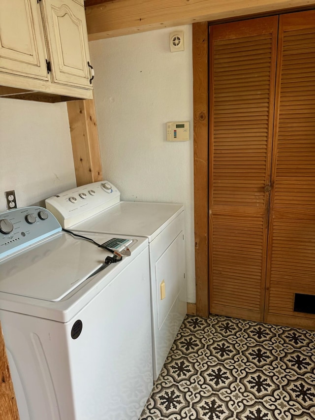 clothes washing area with cabinet space and separate washer and dryer
