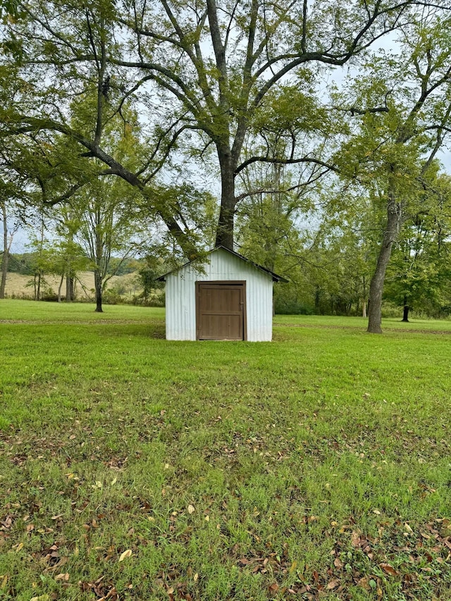 view of grassy yard featuring a shed and an outbuilding
