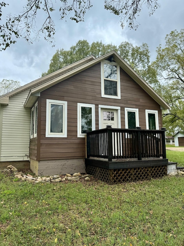 back of house featuring a wooden deck and a lawn