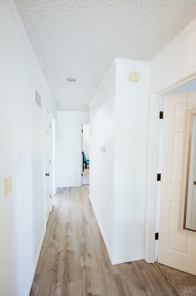 21246 County Road 295, Hermitage, MO 65668 - hall with light wood finished floors, crown molding, a textured ceiling, and baseboards
