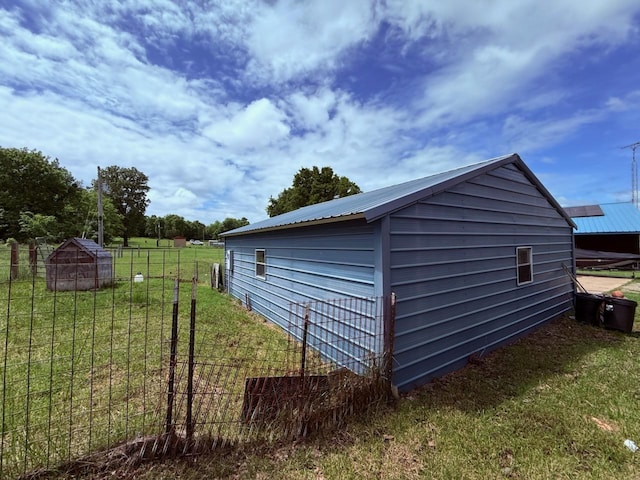 view of side of property featuring metal roof and an outbuilding