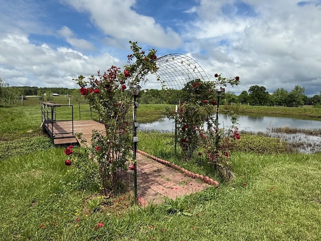 view of green lawn with a water view