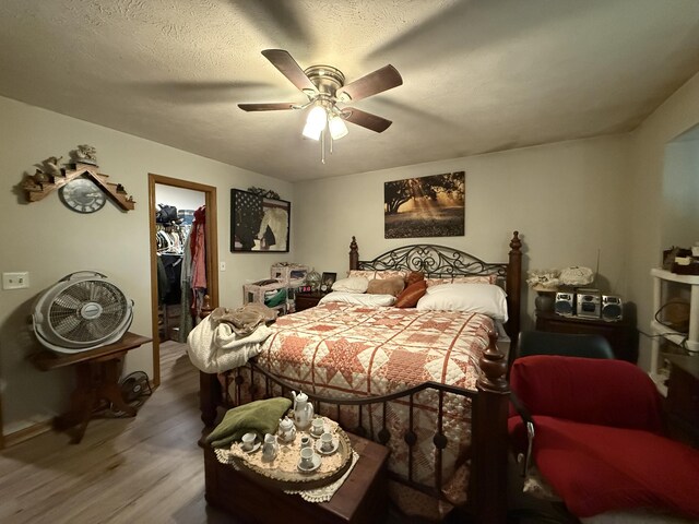 310 Mulling Dr, Highlandville, MO 65669 - bedroom with wood finished floors, a spacious closet, a ceiling fan, a closet, and baseboards