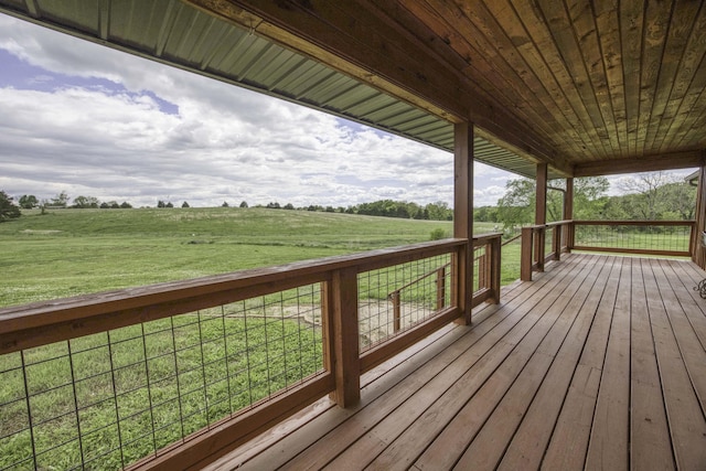 wooden terrace featuring a rural view and a yard