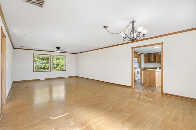 unfurnished living room featuring ornamental molding, a ceiling fan, baseboards, a chandelier, and a sink