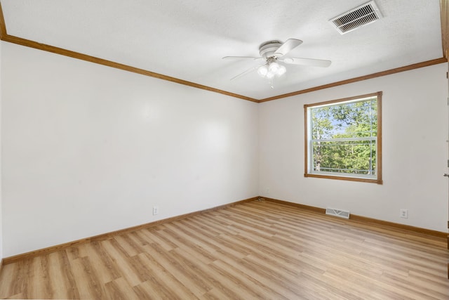 spare room featuring ornamental molding, baseboards, light wood finished floors, and ceiling fan