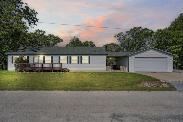 view of front of property with driveway, a yard, an attached garage, and a deck