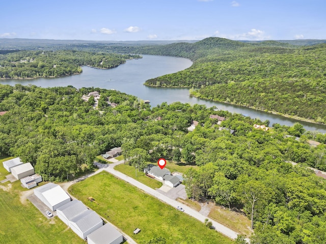 drone / aerial view of a heavily wooded area and a large body of water