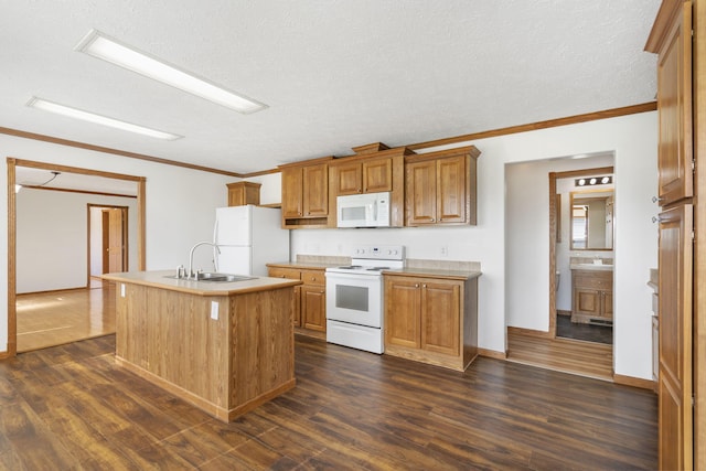 kitchen featuring white appliances, a sink, dark wood finished floors, a center island with sink, and crown molding