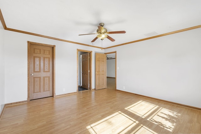 unfurnished room with light wood-style flooring, ceiling fan, baseboards, and crown molding