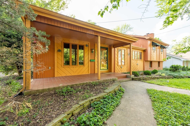 property entrance featuring a porch and a chimney