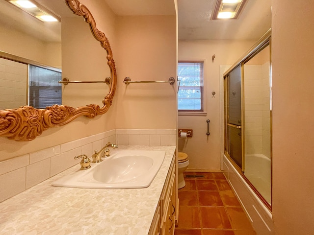 full bathroom featuring vanity, shower / bath combination with glass door, toilet, and tile patterned floors