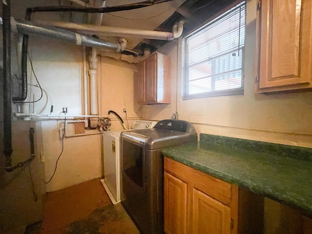 clothes washing area with cabinet space and washing machine and clothes dryer