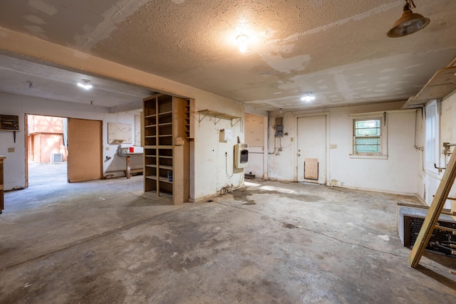 below grade area with heating unit and a textured ceiling