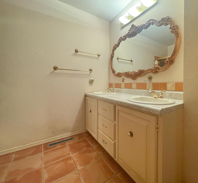 full bath featuring tile patterned flooring, double vanity, and a textured ceiling