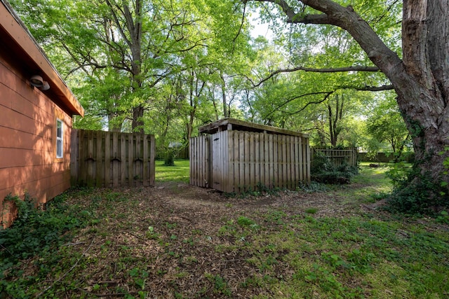 view of yard with a shed, an outdoor structure, and fence
