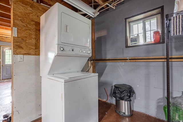 clothes washing area with stacked washing machine and dryer