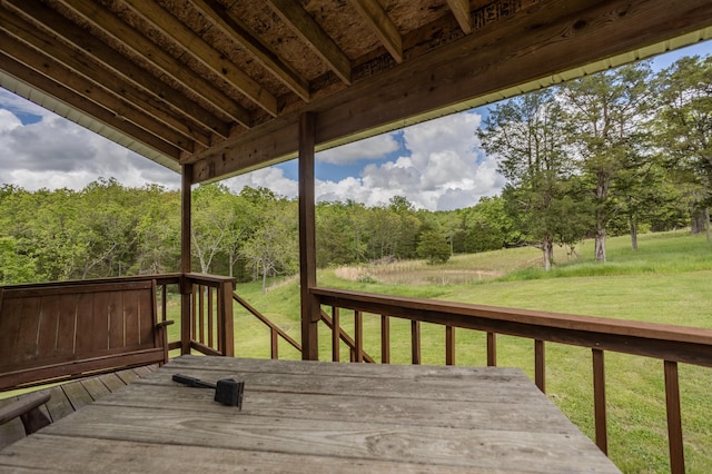 wooden terrace featuring a lawn