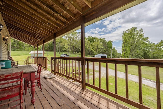 deck with a yard, an outdoor structure, and a shed