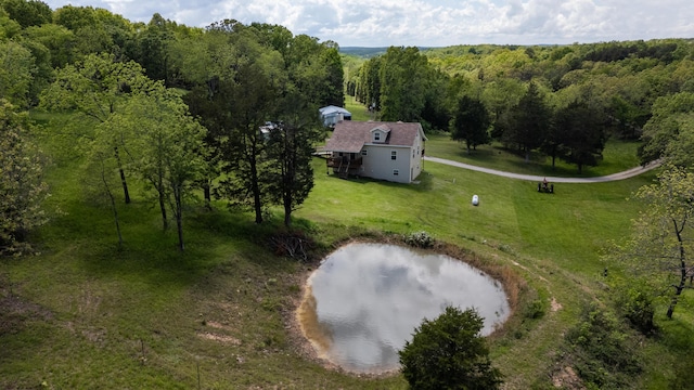 aerial view of property and surrounding area with a nearby body of water and a forest