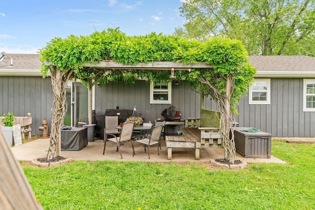 rear view of house with a patio area, a yard, and roof with shingles