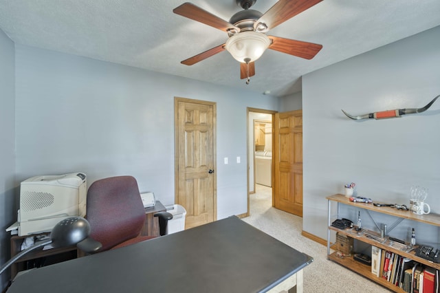 office area with a ceiling fan, light carpet, and baseboards