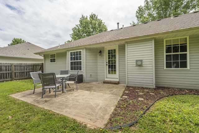 rear view of property with a patio and a shingled roof