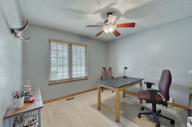 carpeted office featuring ceiling fan, baseboards, and a textured ceiling