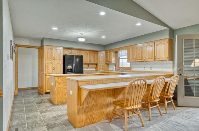 9169 W Farm Road 60, Willard, MO 65781 - kitchen with black fridge, a peninsula, light countertops, a breakfast bar, and decorative backsplash