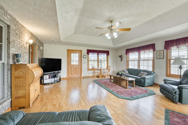9169 W Farm Road 60, Willard, MO 65781 - living area with a raised ceiling, wood finished floors, a textured ceiling, a ceiling fan, and baseboards